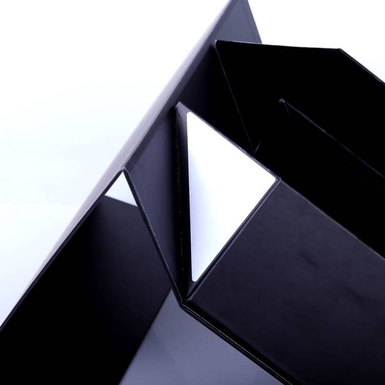 Corner fold of a collapsible magnetic skincare box, showing a white corner panel