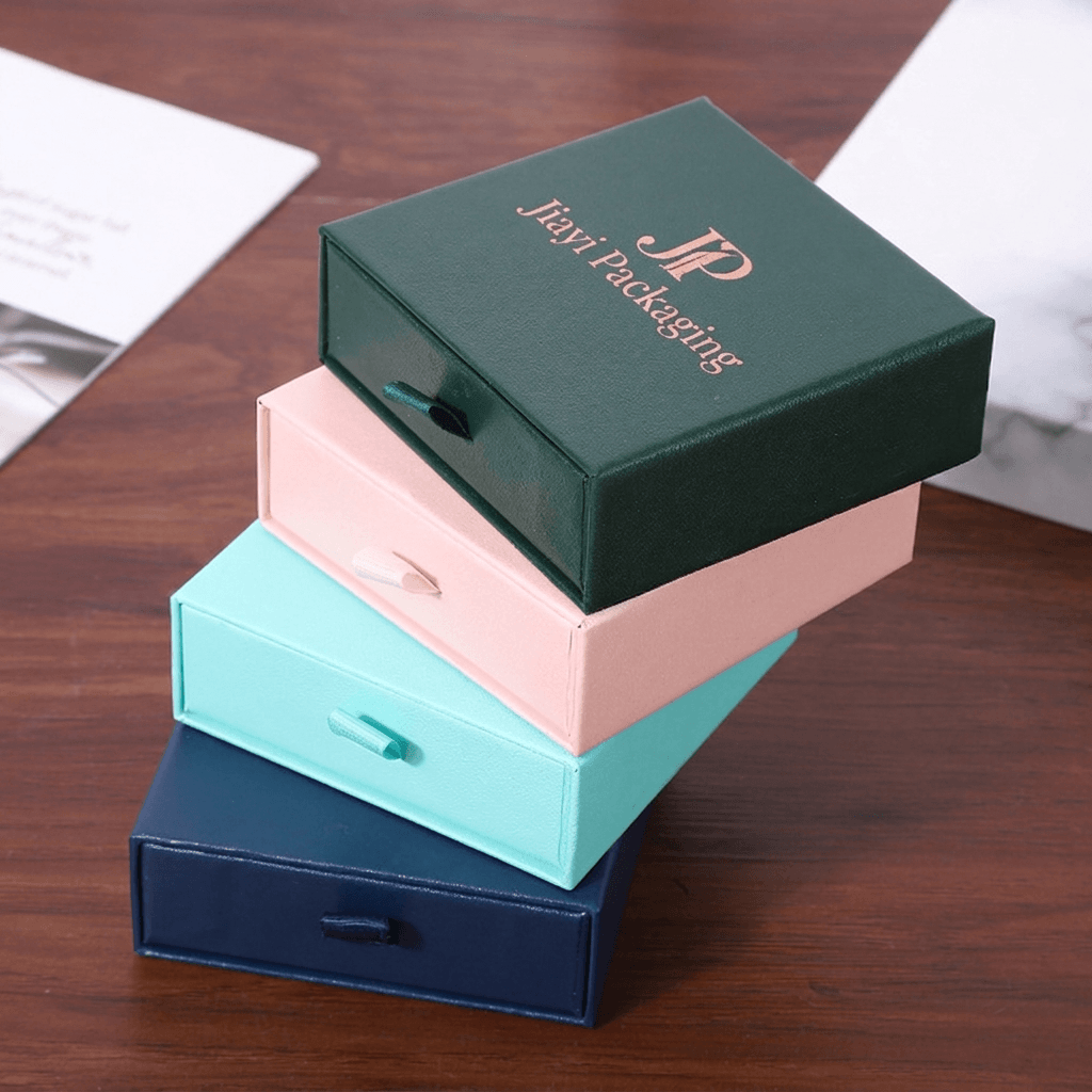 Stacked green, pink, aqua and navy jewelry drawer boxes