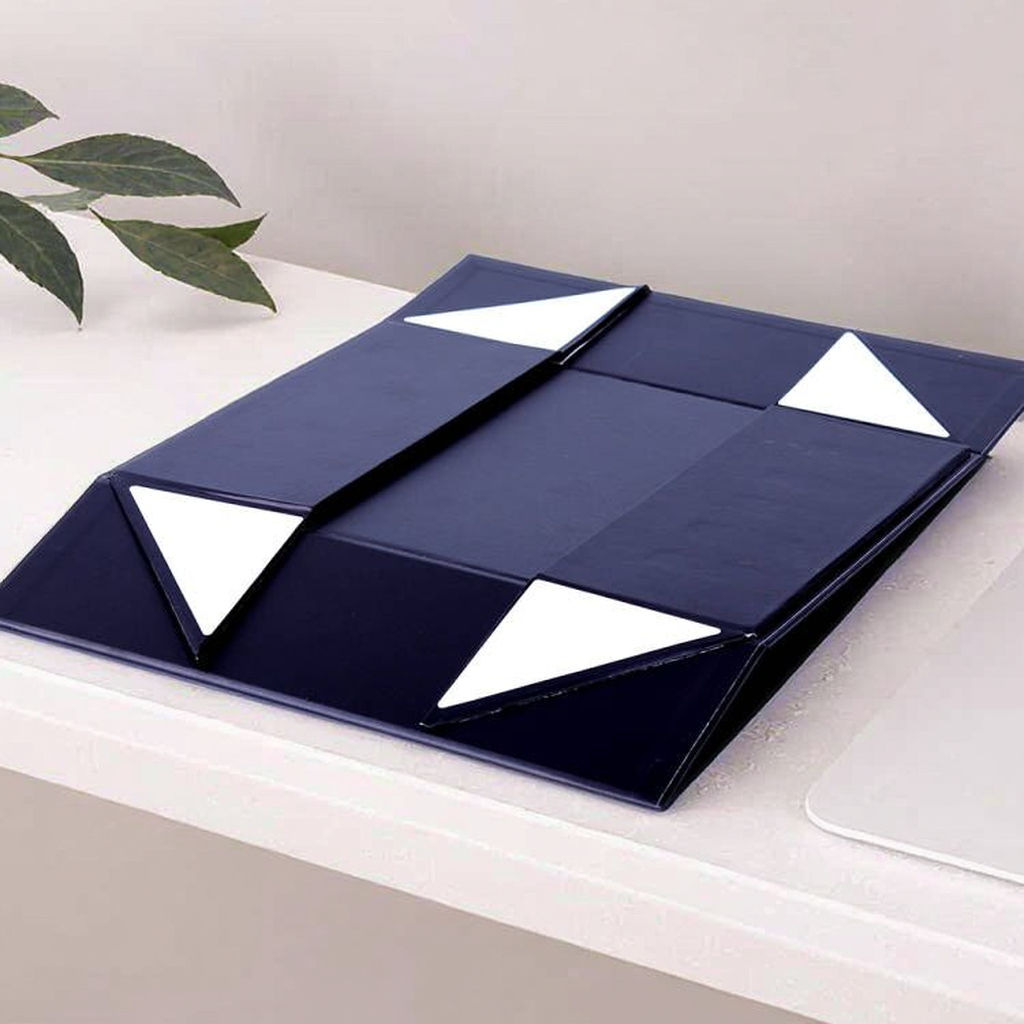 Navy collapsible magnetic skincare box folded flat, with white corner panels at the folds