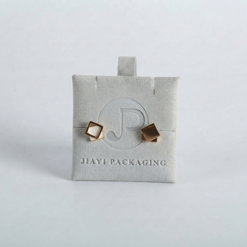 Gray velvet jewelry pouch holding geometric stud earrings