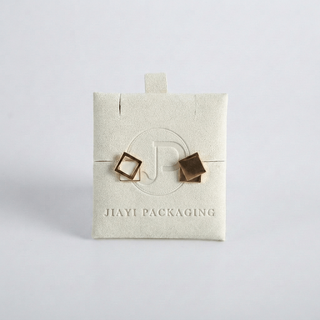 Ivory velvet jewelry pouch holding geometric stud earrings