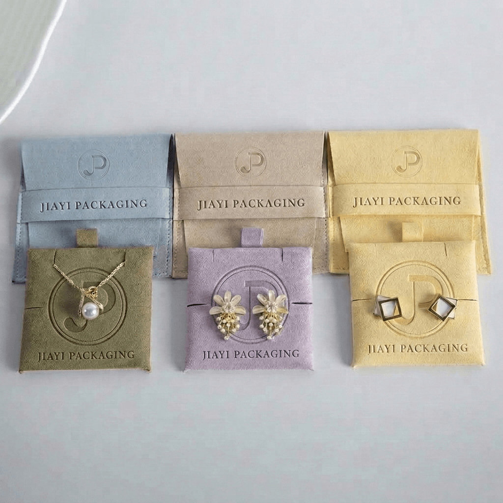 Velvet jewelry envelope pouches and square pads with earrings and a necklace